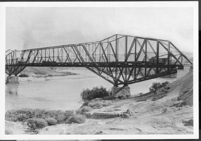 A bridge over the Colorado River at the Needles, ca.1934 Photograph of a bridge over the Colorado River at the Needles, ca.1934. A continuous truss bridge over the Colorado River on brick pilings. Dusty hills peppered...